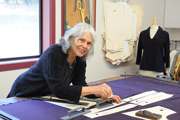 Rose Gerstner, owner of Sympatico, cuts out garments at her pattern table
