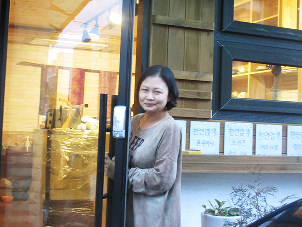 Natural dyer Hee Jin stands in front of her shop and workshop in Jeju, South Korea