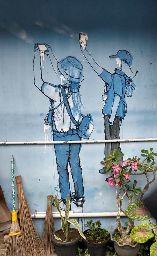 Tourists figure large in this example of street art. 